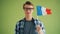 Slow motion portrait of hipster holding flag of France and smiling alone