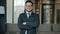 Slow motion portrait of joyful businessman in formalwear and glasses standing in lobby