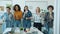 Slow motion portrait of joyful businesswomen dancing and laughing looking at camera in office