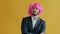 Slow motion portrait of mixed race man taking off pink wig and leaving feeling unhappy