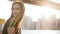 Slow motion portrait of peaceful Caucasian girl with golden hair looking around, enjoying scenic New York sunset view.