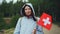 Slow motion portrait of pretty Swiss girl holding flag of Switzerland, smiling and looking at camera. Beautiful