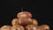 Slow motion. Raindrops falling on a rotating pile of unpeeled potatoes.