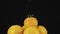 Slow motion. Raindrops falling on a rotating pile of yellow tomato.