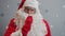 Slow motion of Santa Claus making hush hand gesture with serious face on starry background