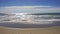 Slow motion sea waves breaking on a sandy beach in Costa dorada, Spain.