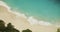 Slow motion of sea waves on a tropical sandy beach. Top down view of stunning blue tropical ocean moving sand on a beach