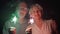 Slow Motion. Senior couple with sparklers celebrating Christmas. Happy family holding bengal lights