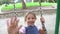 Slow Motion Sequence Of Girl On Swing In Playground Waving