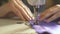 Slow-motion shooting as a sewing machine sews a purple cloth