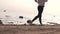 Slow-motion shooting Woman runs barefoot along the sea at sunset on a cool autumn day