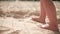 Slow motion shot of a barefoot baby walking on the sand on a summer sunny day