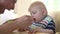 Slow Motion Shot Of Father Feeding Baby Boy In High Chair