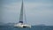 Slow motion shot of graceful sailboat glide through blue turquoise calm water of sea. Tropical summer vacation dream