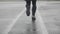 Slow motion shot of legs of a runner in sneakers. Male sports man jogging outdoors. Single runner running in rainy