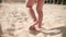 Slow motion shot of a little barefoot baby walking on the sand of the beach