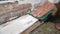 Slow motion shot of a man`s hand sanding the edge of a worn window sill