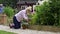 Slow motion shot of mature couple at work watering and planting flowers in garden at home