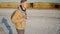 Slow motion shot of young adult man walking at lake coast with white salty flats and steep clay shore