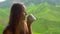 Slow Motion shot of a young woman sitting in a cafe with a view on highlands tea terraces and drinking tea