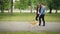 Slow motion side view of attractive young man dog owner walking his pet and chatting to his girlfriend going hand in