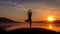 Slow motion silhouette of a young girl trains yoga in the sunset, mountains background.