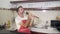 SLOW MOTION singing in kitchen - young cool and attractive man in red apron singing and dancing happy holding spoon as microphone