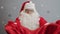 Slow motion of smiling guy in Santa Claus costume giving bag with gifts to camera