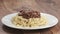 Slow motion sprinkle spaghetti bolognese with grated aged parmesan cheese