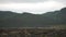 Slow motion stone wall scene of rain with defocused mountains in the background