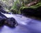 Slow-motion time-lapse of blurry running water landscape river and green rainforest along Santa Cruz Trek near Huaraz, Peru