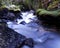 Slow-motion time-lapse of blurry running water landscape river and green rainforest along Santa Cruz Trek near Huaraz, Peru