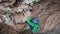 slow motion top view strong woman rock climber climbs on overhanging cliff by hard route. woman makes tough effort and