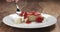 Slow motion of trying to eat strawberry cheesecake with fork on wood table