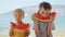 Slow-motion of two cute boys savoring sweet watermelon on a sea beach towel. Spirit of summertime, holiday delights