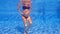 In this slow-motion underwater video, a pregnant woman is seen performing water exercises in a swimming pool. With her