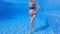 In this slow-motion underwater video, a pregnant woman is seen performing water exercises in a swimming pool. With her