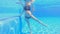 In this slow-motion underwater video, a pregnant woman is seen performing water exercises in a swimming pool. With her