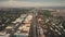 Slow motion urban cityscape with streets at traffic roads, green trees at buildings in aerial view