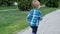 Slow motion video of adorable barefoot toddler boy running on footpath at park