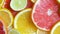 Slow motion video of assortment of fresh citrus fruits lying on table