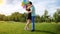 Slow motion video of beautiful young couple holding lots of colorful balloons and hugging at park