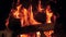 Slow motion video of burning wooden logs in the firepalce at night