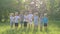 Slow-motion video. A group of children, friends of boys and girls, are standing in the park on a sunny summer day in a