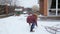 Slow motion video of happy teenage girl having snow ball fight at house backyard