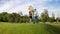 Slow motion video of happy young couple walking in park with bunch of colorful balloons