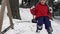 Slow motion video of a little girl swinging on the swing while someone throws snowballs on her