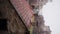 Slow motion video. Spring snow damage roof. Leafless outdoor. Dirty old bricks