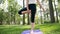 slow motion video of yoga and fitness on grass at park. Middle aged smiling woman practicing and doing exercises on