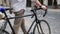 Slow motion video of young man walking with old vintage bicycle on street